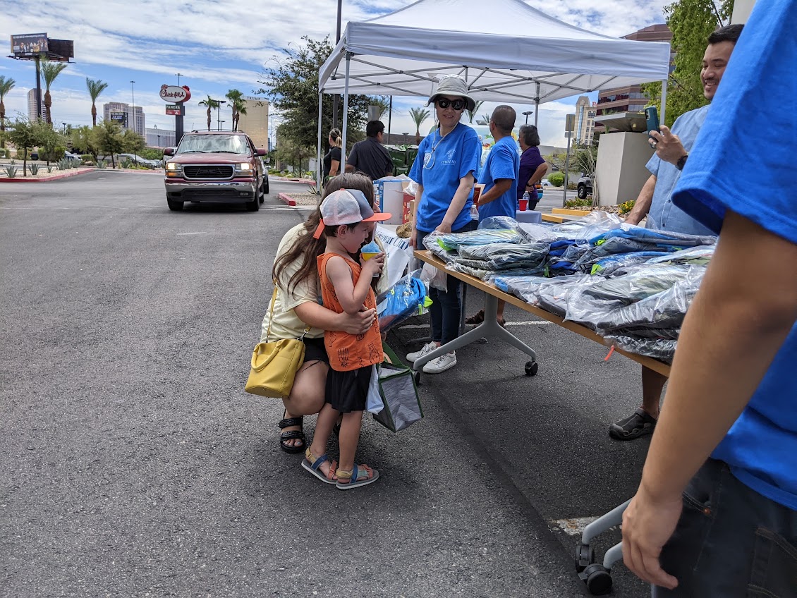 A child receives clothing at the Back to School distribution table